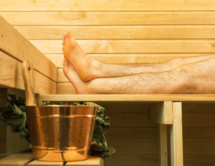 Spa accessories in sauna. Man on background.