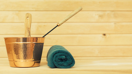 Metal bucket and towel in sauna. Place for text.