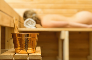 Fototapeta na wymiar Spa accessories in sauna. Woman on background.