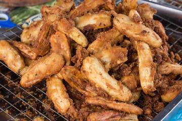 Fried bananas are one of Thai snacks. Bananas to be cut or sliced in half, and dip into dough. Then cook them with hot oil in a frying pan. 