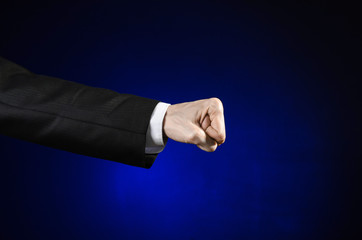 Obraz premium Businessman and gesture topic: a man in a black suit and white shirt showing hand gesture on an isolated dark blue background in studio