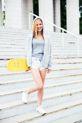 Girl standing on stairs with skateboard