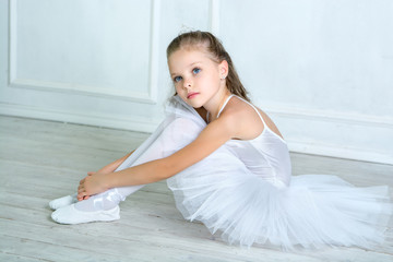 A little adorable young ballerina in a playful mood in the inter © jutaphoto