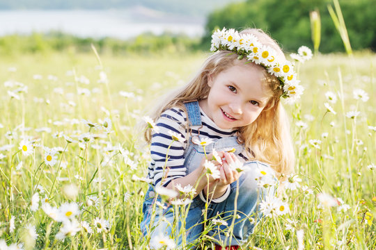 happy little girl in the chamomile field