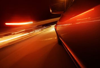 Obraz na płótnie Canvas Fast driving by night - motion blur red