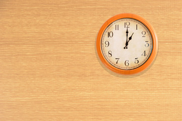 Clock showing 1 o'clock on a wooden wall