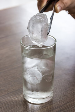 taking ice cubes  on a gin tonic session - focus on the ice cube