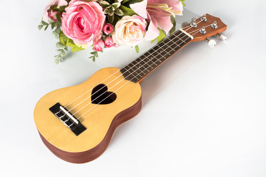 Ukulele and beautiful flower on white background