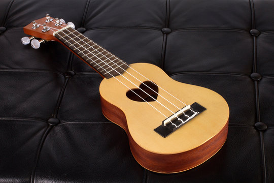Ukulele on black leather arm chair