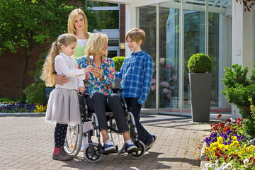 Grandchildren visiting grandmother in wheelchair.