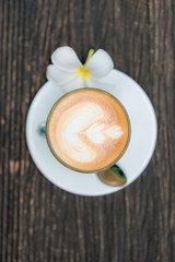 Top view of offee cup and flower on old wooden background
