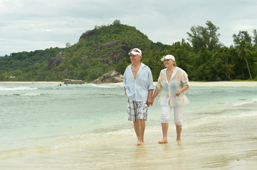 Elderly couple running  on beach