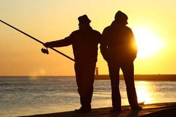 Homens a pescar ao por-do-sol.
