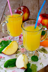 Drink freshly squeezed orange and apple juice on a wooden table