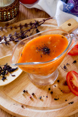 Tomato sauce in a glass gravy boat on a wooden table