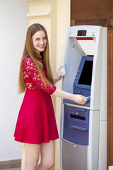 Fototapeta na wymiar Blonde lady using an automated teller machine