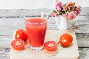 Glass of tomato juice with vegetables on wooden