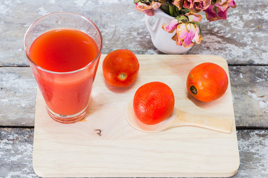 Glass of tomato juice with vegetables on wooden
