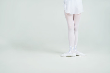 Foot in pointe ballet shoes of young ballerina poses on camera
