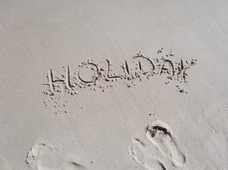 Inscription holiday on beach sand