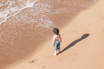 Child boy on beach water ocean explore playtime