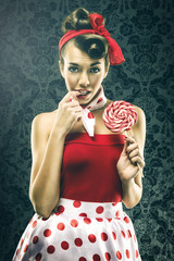 Pretty sexy woman in red vintage polka dot dress - with lollipop
