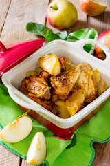 Baked chicken with apples on wooden table