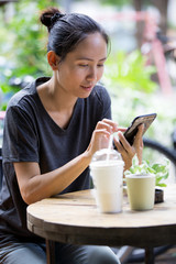 Young Asian woman  using smartphone in garden