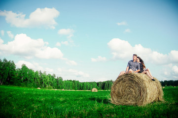 Naklejka na ściany i meble lovers resting in a field near haystacks 