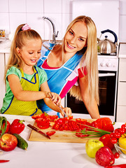Mother and daughter cooking at kitchen.