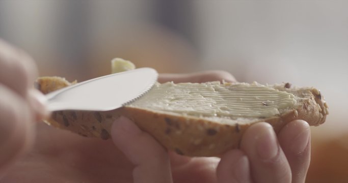 Man spreads the bread with butter