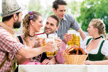 Leute mit Bier und Bretzel in Biergarten