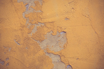 Texture of old rustic wall covered with yellow stucco vintage co