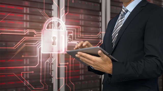 Businessman using tablet in front of locked server