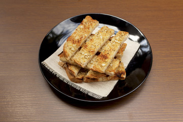 Garlic bread on black plate with space on wood background