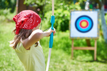 Girl with bow shooting to sport aim - obrazy, fototapety, plakaty