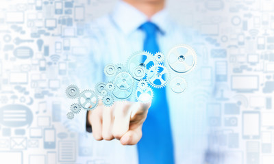 Businessman activating gears mechanism