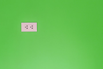 Fototapeta na wymiar White electric outlet mounted on green wall