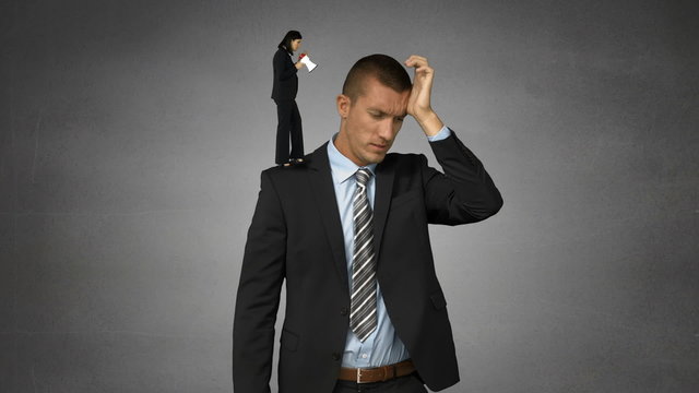 Small female boss yelling on businessman with megaphone