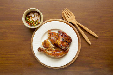 Grilled chicken with spicy sauce on wood background