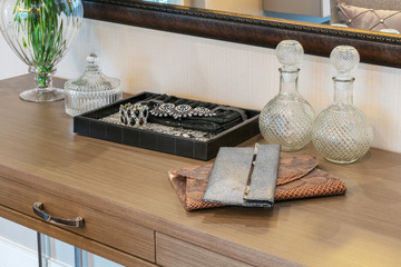 handbag and jewelry set on a dresser table in a contemporary roo