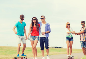 Obraz premium group of smiling teenagers with skateboards