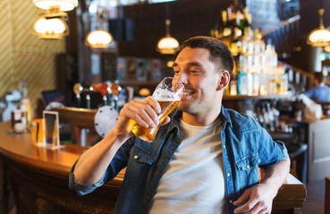 happy man drinking beer at bar or pub