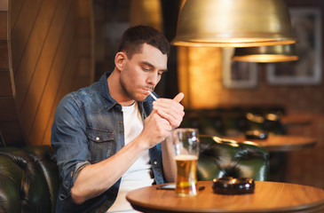 man drinking beer and smoking cigarette at bar