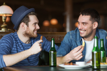 happy male friends drinking beer at bar or pub