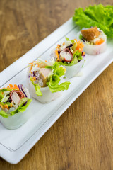 Portion of spring rolls , vegetables and in noodle tube