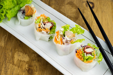 Portion of spring rolls , vegetables and in noodle tube