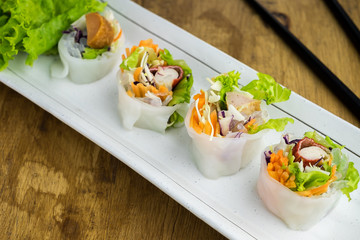 Portion of spring rolls , vegetables and in noodle tube