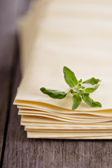 Raw lasagna sheets on wooden table