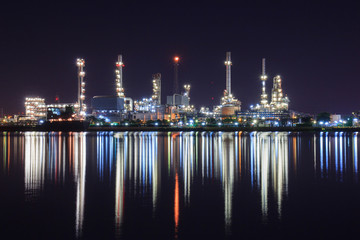 Petrochemical plant at night with reflection on water